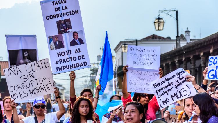 Guatemalteken wehen mit Fahnen und Slogans vor dem Rathaus in Antigua aus Protest gegen Korruption im Land.